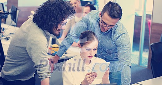 Group of a young business people discussing business plan at modern startup office building Group of a young business people discussing business plan at modern startup office building