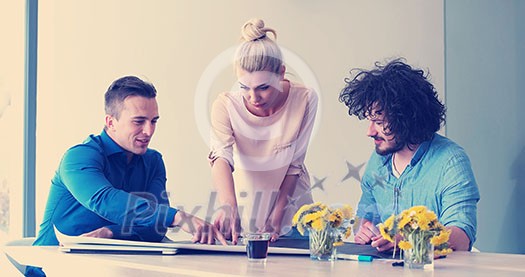 Group of a young business people discussing business plan at modern startup office building Group of a young business people discussing business plan at modern startup office building