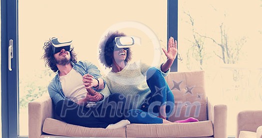 Multiethnic Couple using virtual reality headset in living room at home  people playing game with new trends technology