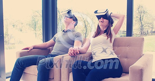 Couple using virtual reality headset in living room at home  people playing game with new trends technology