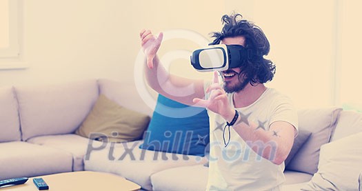 happy man getting experience using VR-headset glasses of virtual reality at home