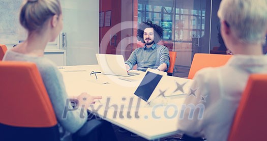 Group of a young business people discussing business plan at modern startup office building Group of a young business people discussing business plan at modern startup office building
