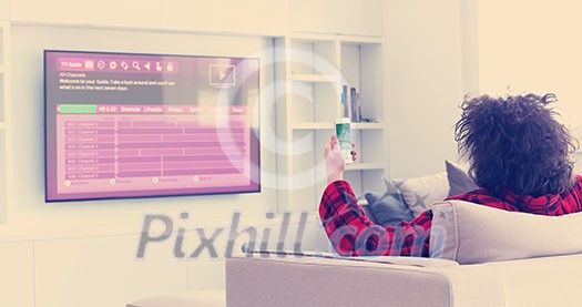 Young couple on the sofa watching television together in their luxury home Young couple on the sofa watching television together in their luxury home