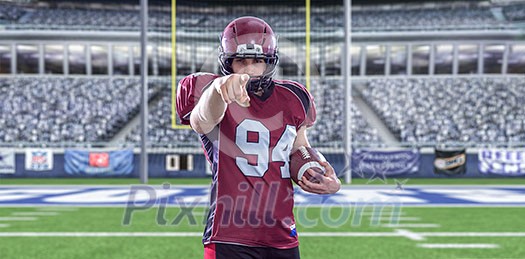 Portrait of American football player pointing against gray background Portrait of American football player pointing against gray background