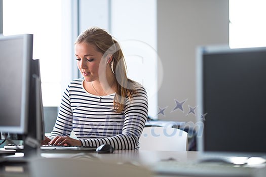 Pretty, female student looking at a desktop computer screen, learning unpleasant news about her exam results. University/office/school concept Pretty, female student looking at a desktop computer screen, learning unpleasant news about her exam results. University/office/school concept