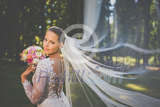 Brunette bride in fashion white wedding dress with makeup. Wedding day of bride in bridal gown. Beauty woman and bouquet. Fashion brunette model outdoors. Portrait beauty model in white bridal dress