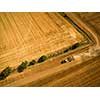 Aerial view of a tractor working a field after harvest