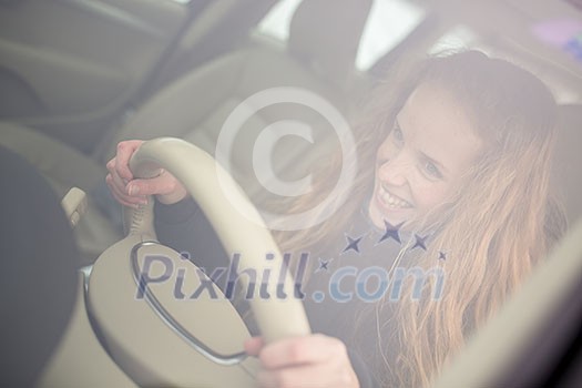 Pretty young woman driving her new car