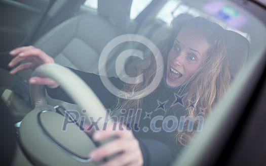 Pretty young woman driving her new car (shallow DOF; color toned image)