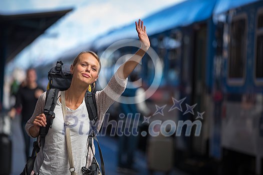 Pretty young woman boarding a train/having arrived to her destination, waiting for her friends to pick her up (color toned image) Pretty young woman boarding a train/having arrived to her destination, waiting for her friends to pick her up (color toned image)