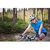 Pretty, young female biker outdoors on her mountain bike (shallow DOF; selective focus)