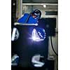 Industrial workers welding metal with many sharp sparks, Welder working a welding metal with protective mask and sparks