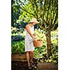 Pretty, young woman gardening in her garden - harvesting organic apples - looking very happy with the results