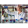 Female researcher carrying out scientific research in a lab (shallow DOF; color toned image)