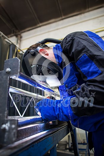 Industrial workers welding metal with many sharp sparks, Welder working a welding metal with protective mask and sparks