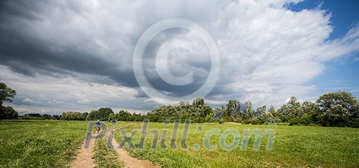 Mountain biking women riding on bike in summer landscape Mountain biking women riding on bike in summer landscape