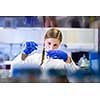 Portrait of a female researcher carrying out research in a chemistry lab (color toned image; shallow DOF)