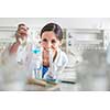 Young, female researcher carrying out experiments in a lab (shallow DOF; color toned image)