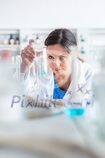 Young, female researcher carrying out experiments in a lab (shallow DOF; color toned image) Young, female researcher carrying out experiments in a lab (shallow DOF; color toned image)
