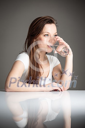 Closeup portrait of pensive young attractive woman drinking a glass healthy fresh water