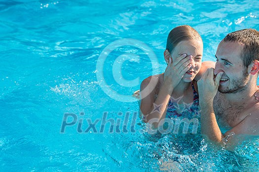 Brother and sister in a swimming pool on a summer day