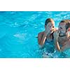 Brother and sister in a swimming pool on a summer day