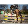 Young woman show jumping with horse