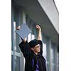 Pretty, young woman celebrating joyfully her graduation - cheking her diploma, happy/impressed with the title she received (color toned image; shallow DOF)