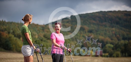 Pretty, young woman nordic walking on a forest path, taking in the fresh air, getting the daily dose of exercise