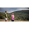 Pretty, young woman nordic walking on a forest path, taking in the fresh air, getting the daily dose of exercise