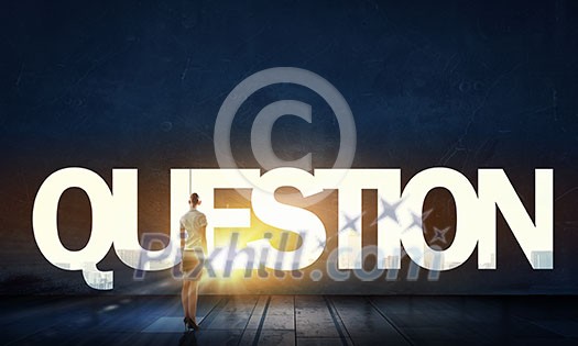 Back view of businesswoman standing in light of question mark Back view of businesswoman standing in light of question mark