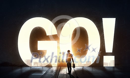 Back view of businessman standing in light of GO word