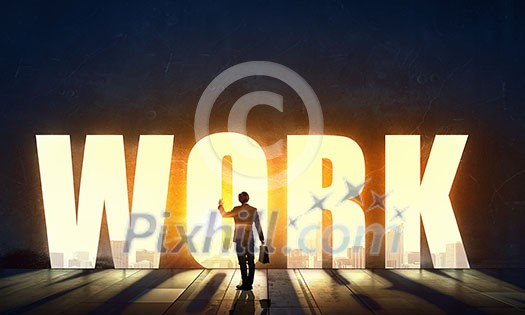 Back view of businessman standing in light of word work Back view of businessman standing in light of word work