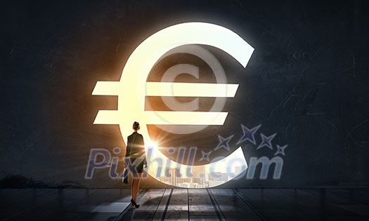 Silhouette of businesswoman in light of big euro symbol Silhouette of businesswoman in light of big euro symbol