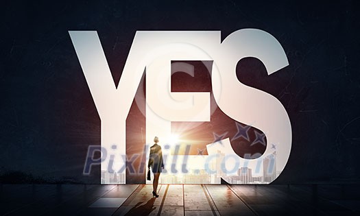 Back view of businesswoman standing in light word yes Back view of businesswoman standing in light word yes