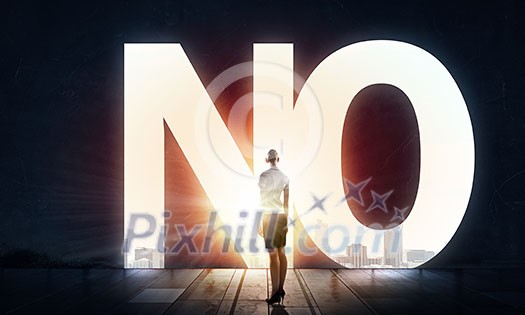 Back view of businesswoman standing in light of word no Back view of businesswoman standing in light of word no
