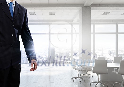Close view of elegant businessman against modern ofiice window Close view of elegant businessman against modern ofiice window