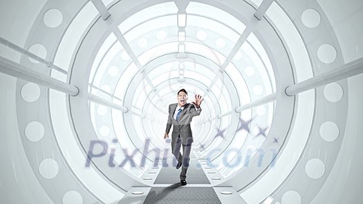 Young screaming businessman running in futuristic tunnel Young screaming businessman running in futuristic tunnel