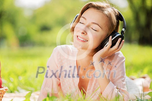 Young pretty lady in park listening to music Young pretty lady in park listening to music