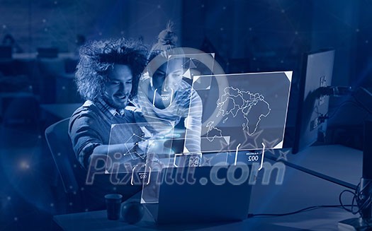 Two young designers are working on a new project in the night office using modern technology Two young designers are working on a new project in the night office using modern technology