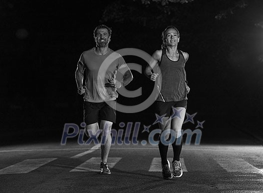 group of healthy people jogging in city park, runners team at night training