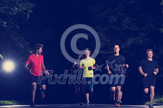 group of healthy people jogging in city park, runners team at night training group of healthy people jogging in city park, runners team at night training