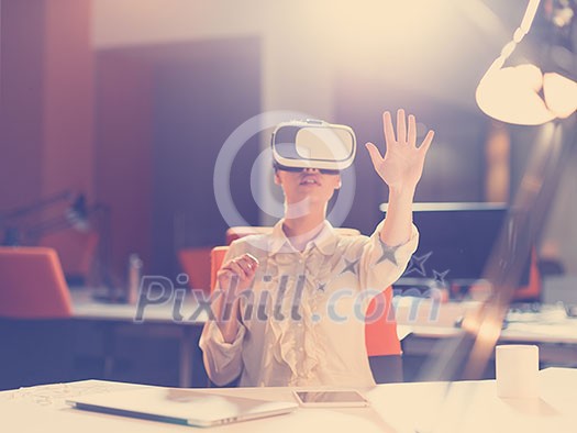 young businesswoman getting experience using VR-headset glasses of virtual reality at late night  startup office building