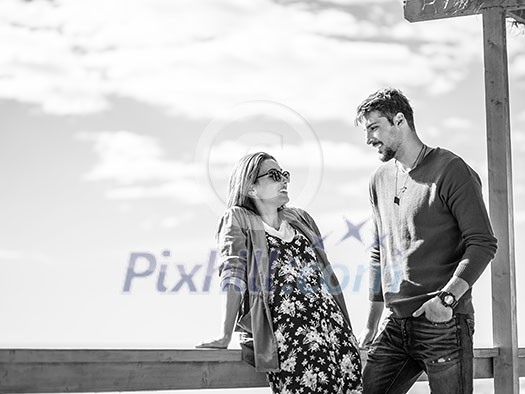 Happy couple enyojing time together on beach during autumn day Happy couple enyojing time together on beach during autumn day