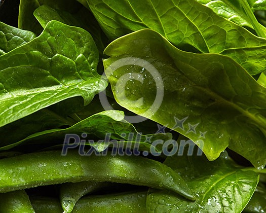 Close-up organic fresh green vegetables background. The green spinach ang peas for cooking a vegetarian salad. Clean detox food.