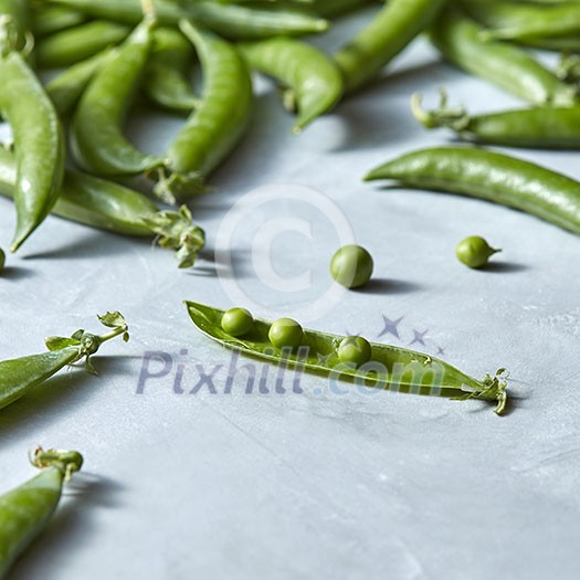 Freshly picked green peas on a gray with copy space. Natural vegetarian detox dieting. Freshly picked green peas on a gray with copy space. Natural vegetarian detox dieting.