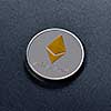 Silver Ethereum coin with a golden symbol represented on a dark background. Conceptual image for worldwide cryptocurrency and digital payment system. Top view