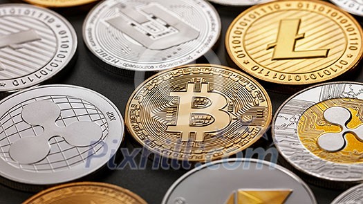 A pattern from different coins of crypto currency on a dark background. Gold and silver coins ripple, bitcoin, litecoin, ethereum, dash. Business concept. Top view