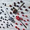 Colorfiul pattern of three spoons with various berries on a gray wooden background. Concept of healthy organic eating