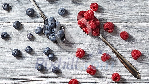 Sweet berries pattern from organic ripe fresh bluberry and raspberry on gray background. Healthy clean eating. Flat lay